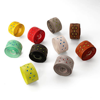 Small rolled baseball bat grip tapes with hexagon patterns in assorted bright colors